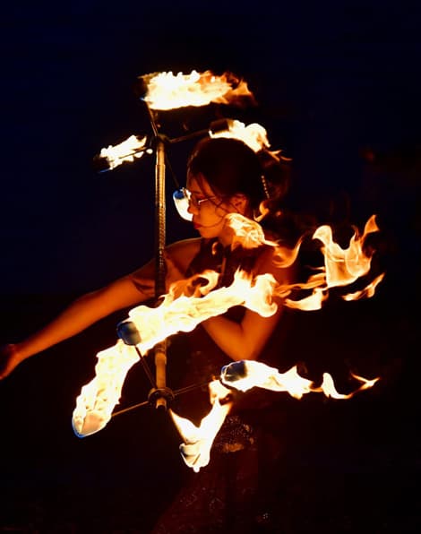 A fire performer trailing flame in a long exposure.